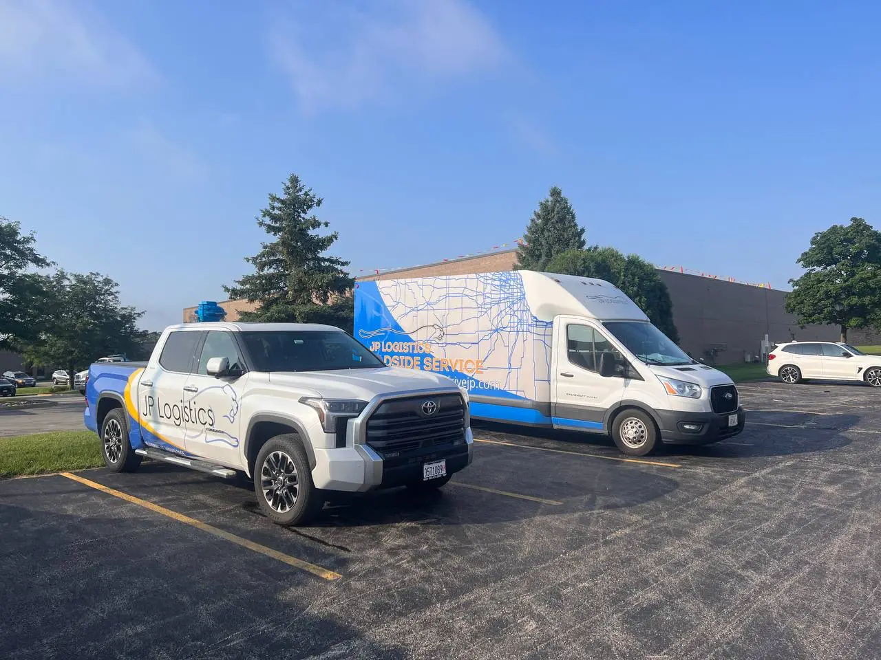 JP Logistics branded vehicles - pickup truck and delivery van